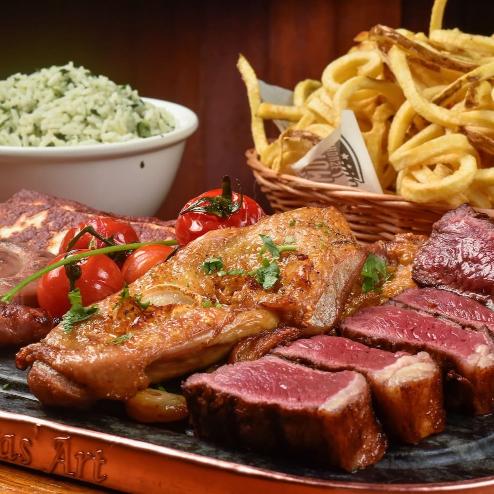 Corte selecionado de picanha fatiada (300g), dois filés de coxa, linguiça artesanal e três tiras de queijo coalho. Escolha seus dois acompanhamentos e um molho.