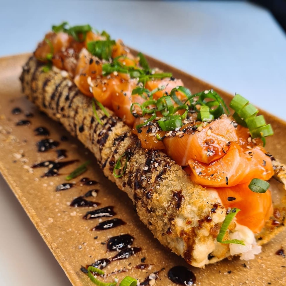 Enrolado de arroz empanado, cream cheese, salmão, cebolinha, teriaki e gergelim