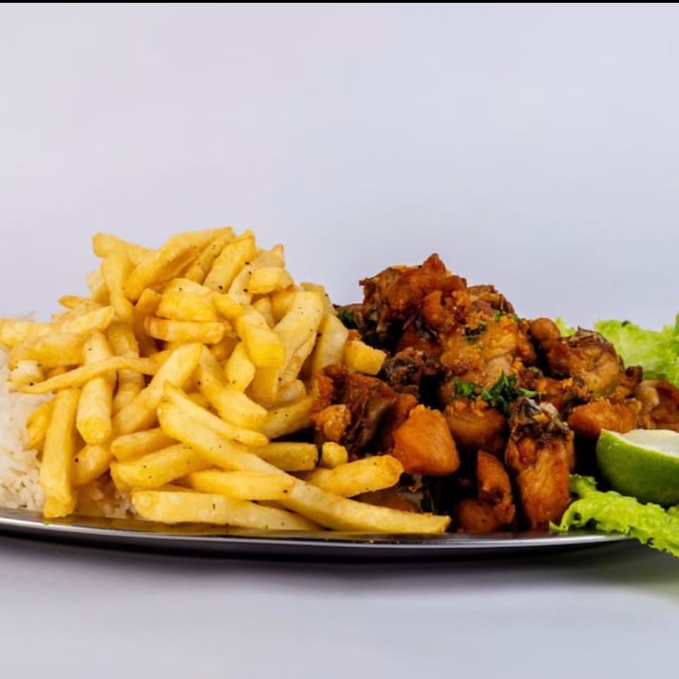 Meia porção de frango á passarinho acompanhado de maia porção de arroz , meia porção de fritas , molho e farofa.