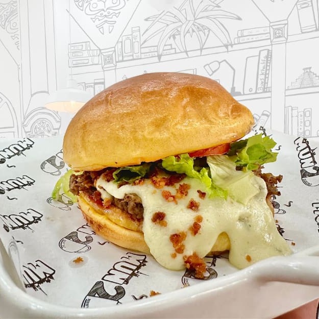 Pão de Brioche com uma deliciosa carne assada desfiada, creme artesanal de 5 queijos, farofa de bacon , alface  e tomate.