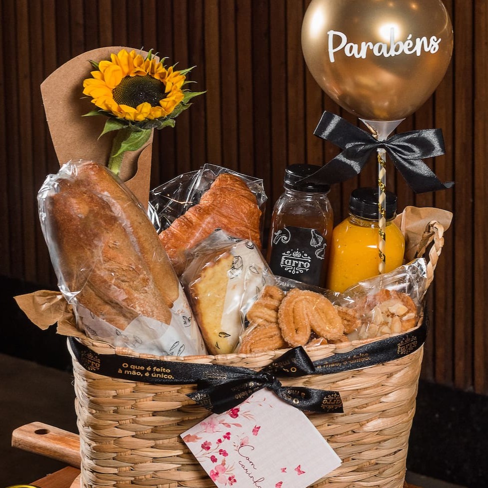 1 Cesta palha, 1 Cartão, 1 Baguete, 1 Espeto de salaminho com picles, 1 Queijo Canastra 100g, 1 Mel em potinho, 1 Geleia em potinho, 1 Mate carioca, 1 Bolo simples, 1 Mini palmier, 2 Croissant simples, 1 Salada de frutas, 1 Cookie