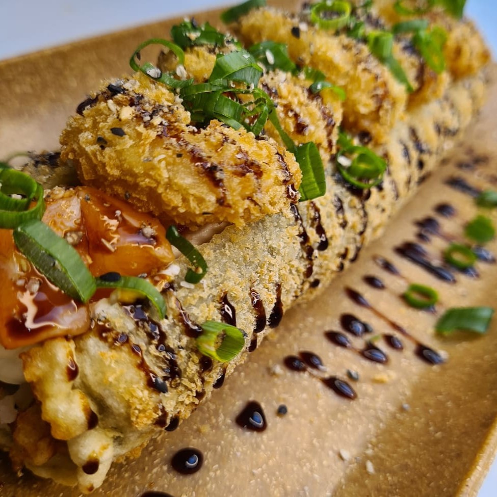 Enrolado de arroz empanado, cream cheese, salmão, camarão empanado, cebolinha, teriaki e gergelim