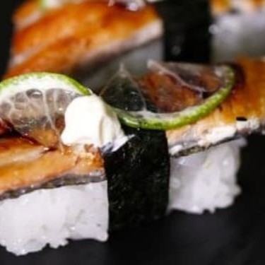 Niguiri de skin é  neta de pele de salmão grelhado por cima e bolinha de arroz por baixo  finalizado com limão