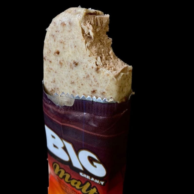 Delicioso sorvete no palito  com cobertura de chocolate , sabor Malt, mas conhecido como Ovomaltine .