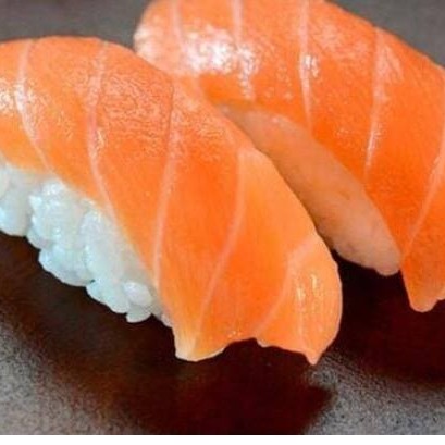 Delicioso salmão fresco fatiado no bolinho de arroz japonês.