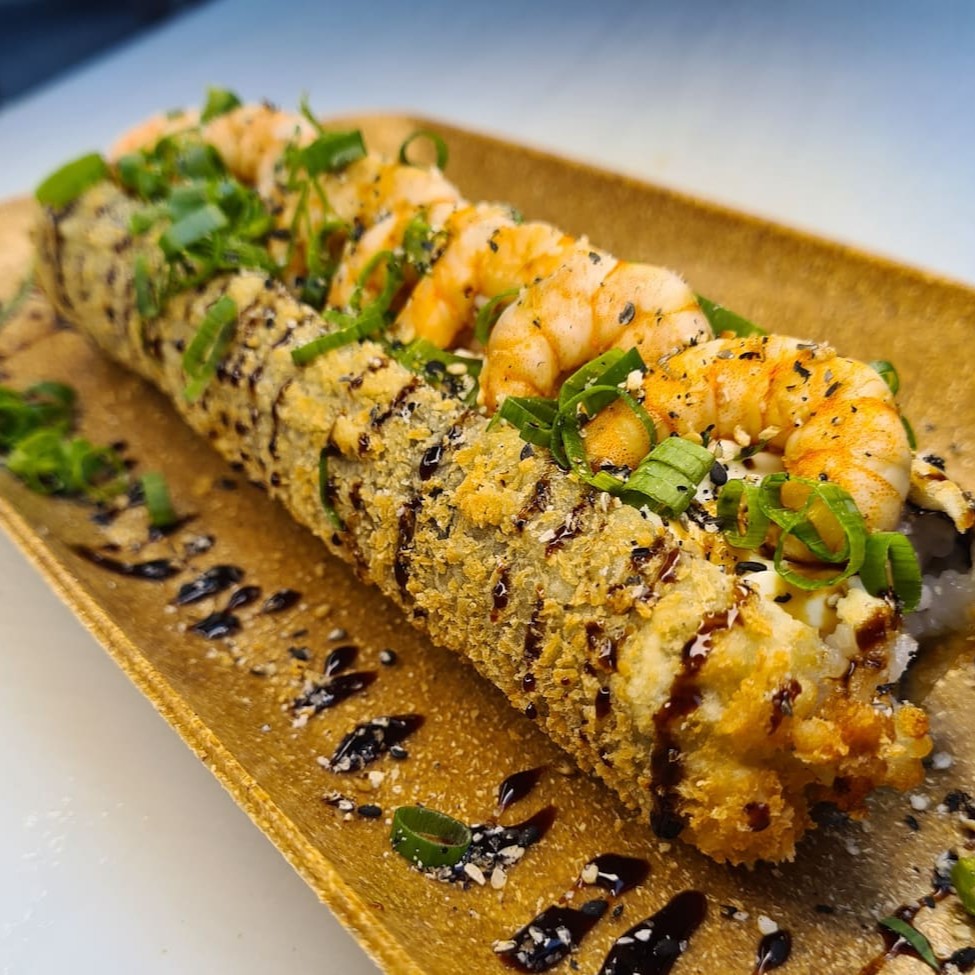 Enrolado de arroz empanado, cream cheese, camarão, cebolinha, teriaki e gergelim