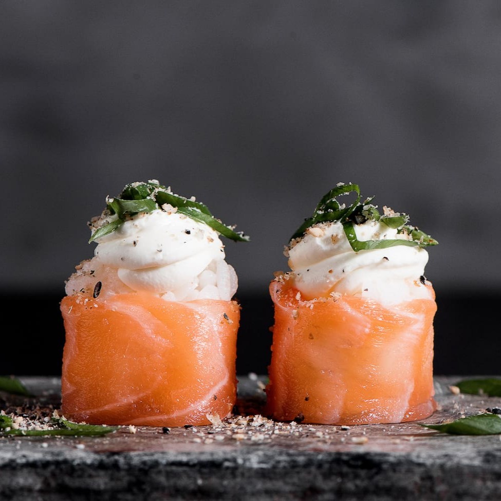 Arroz e cream cheese enrolado na lamina de salmão, finalizado com farofa de gergelim e cebolinha.