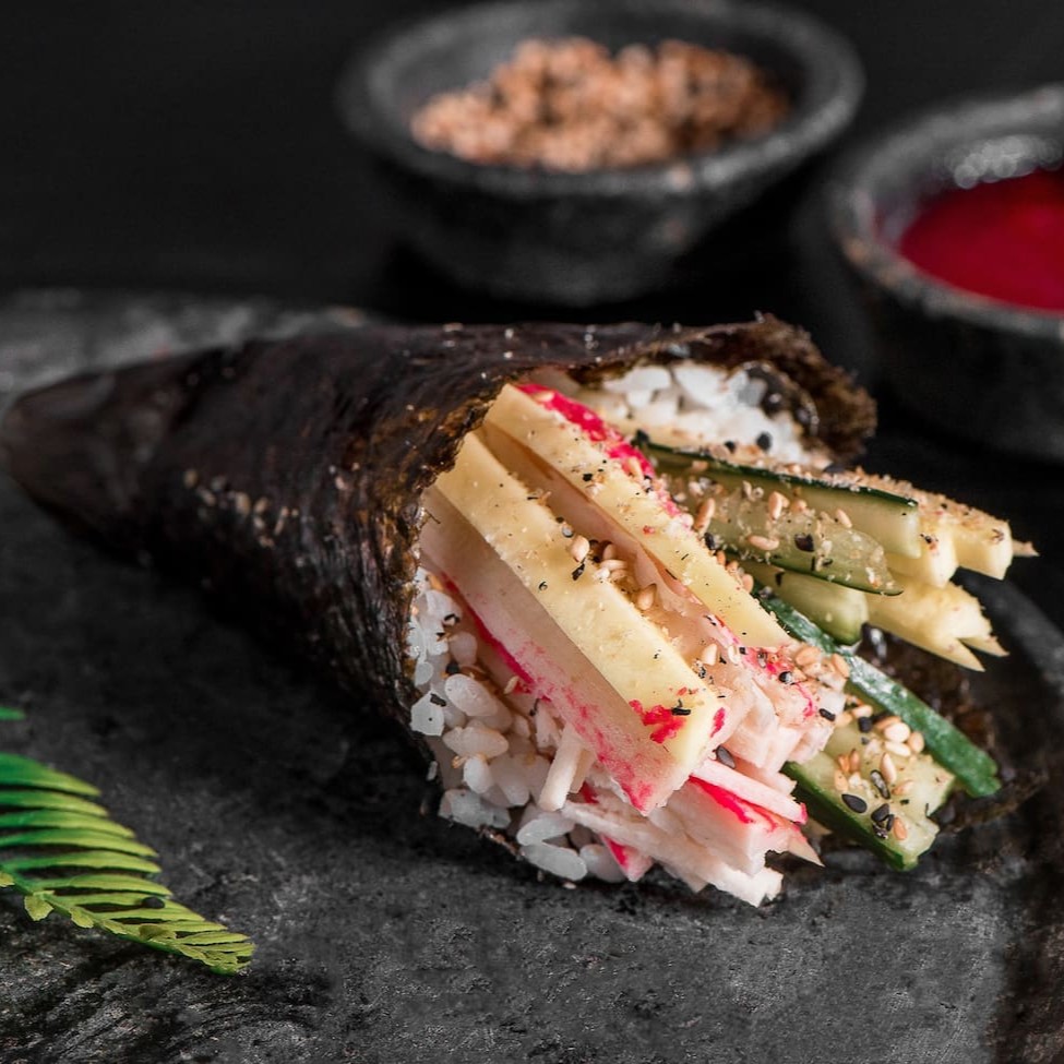 Arroz, manga, pepino e kani, finalizado com farofa de gergelim