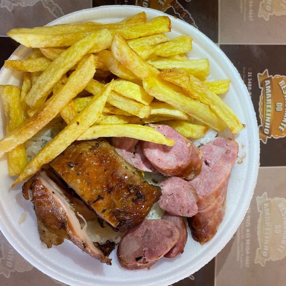 Arroz, feijão, farofa, molho a campanha, coxa sobre coxa e linguiça, batata frita