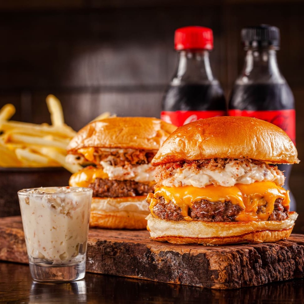 Vai 2 joker bacon(blend 150g, queijo cheddar,farofa de bacon, maionese de bacon, no pão de brioche amanteigado), 1 batatinha própria pra delivery, 1 molho pra batata, 2 Cocas Mini(ou outro).   *Todos nossos burgers são artesanais*