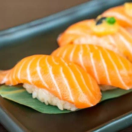 """Porção com 4 unidades de sushi salmão brûlée, preparado com fatias frescas de salmão delicadamente cobertas com uma camada levemente caramelizada, criando uma combinação perfeita entre o sabor suave do peixe e a textura crocante do brûlée. Servido sobre arroz temperado, é uma experiência sofisticada que agrada os paladares mais exigentes."""