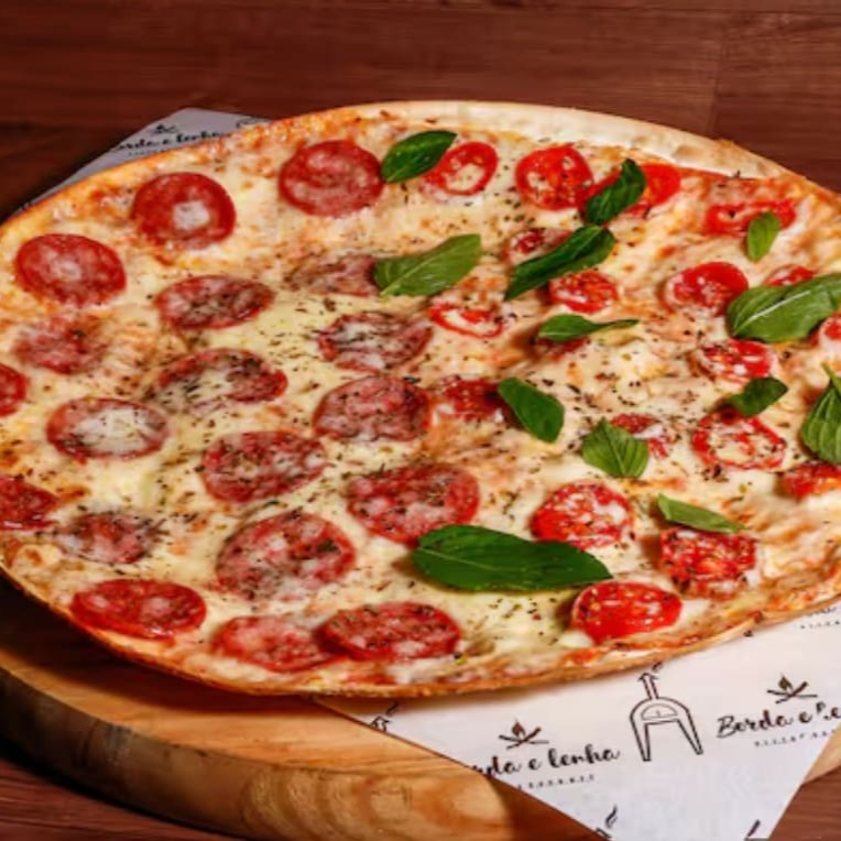 Nossa pizza mais pedida! Compre com 1 Clique! Nossa Massa, Super Fina, leve com Borda crocante, Grande de 35cm, com base de molho de tomate, Mussarela, uma metade calabresa, e a outra metade tomate cereja e manjericão fresco, finalizada com orégano.