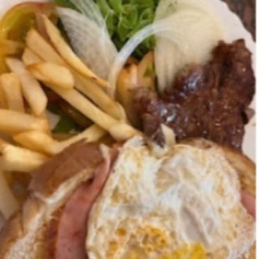 Contra file , um ovo , queijo e presunto no pão de forna , salada e batata frita