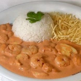 Strogonoff de camarão com cogumelos, acompanhado de arroz e batata palha.