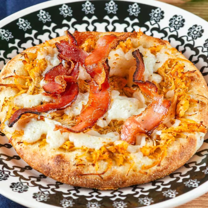 Esfiha Gourmet de Frango com Bacon e Catupiry: Recheio de frango selecionado, Catupiry cremoso e bacon crocante e defumado. Sabor único e irresistível!