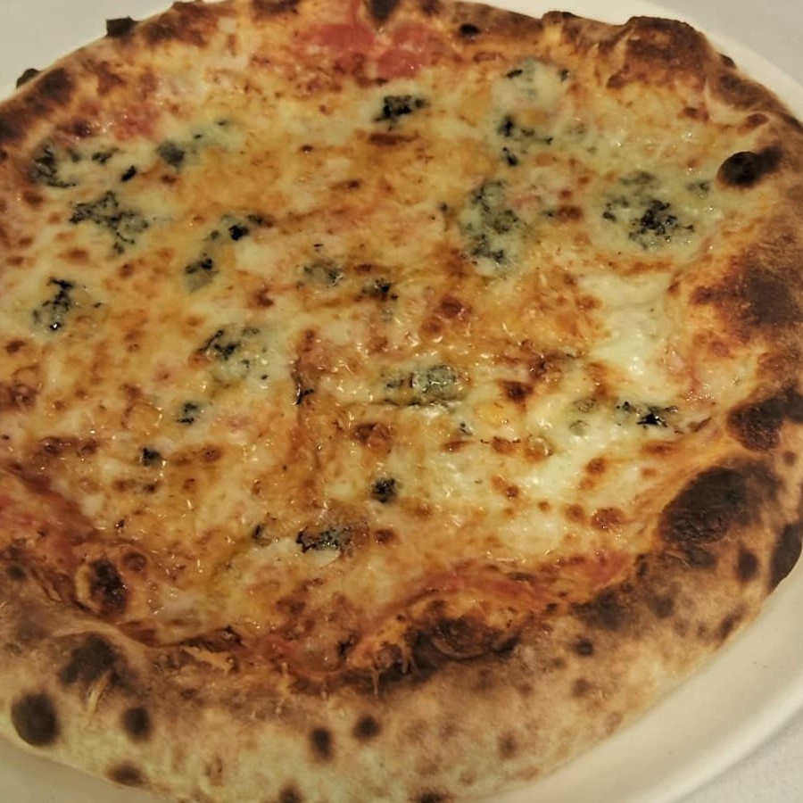 Massa artesanal com tomate pelati, muçarela de bufala cremosa, gorgonzola de sabor intenso e alho-poró crocante.