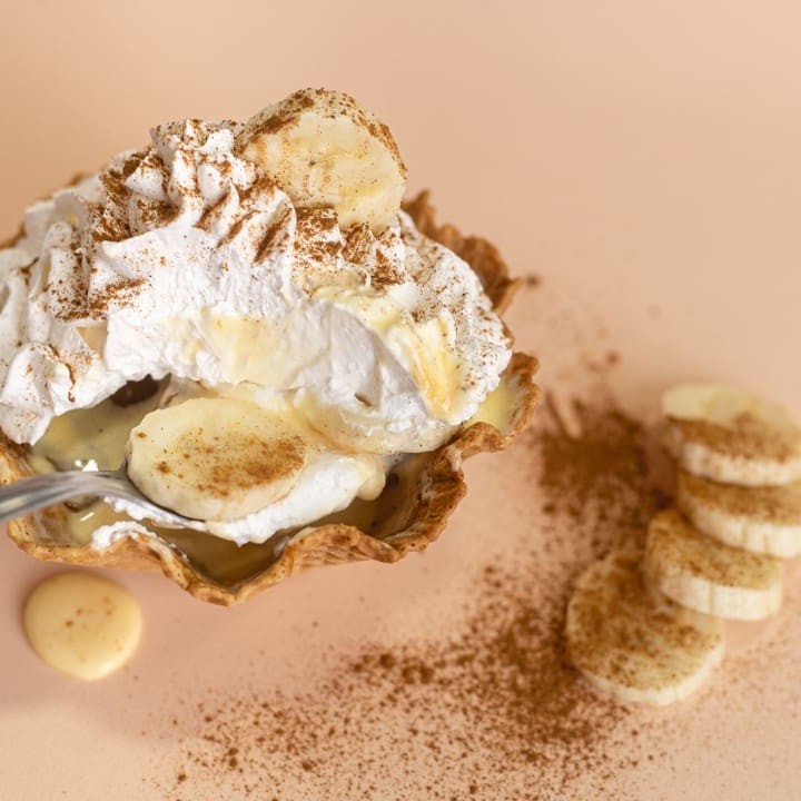 Casquinha de sorvete em pedaços, delicioso sorvete de creme, uma camada de doce de leite, banana em rodelas generosas, chantilly e canela para aromatizar. Você não pode deixar passar essa delícia ;)