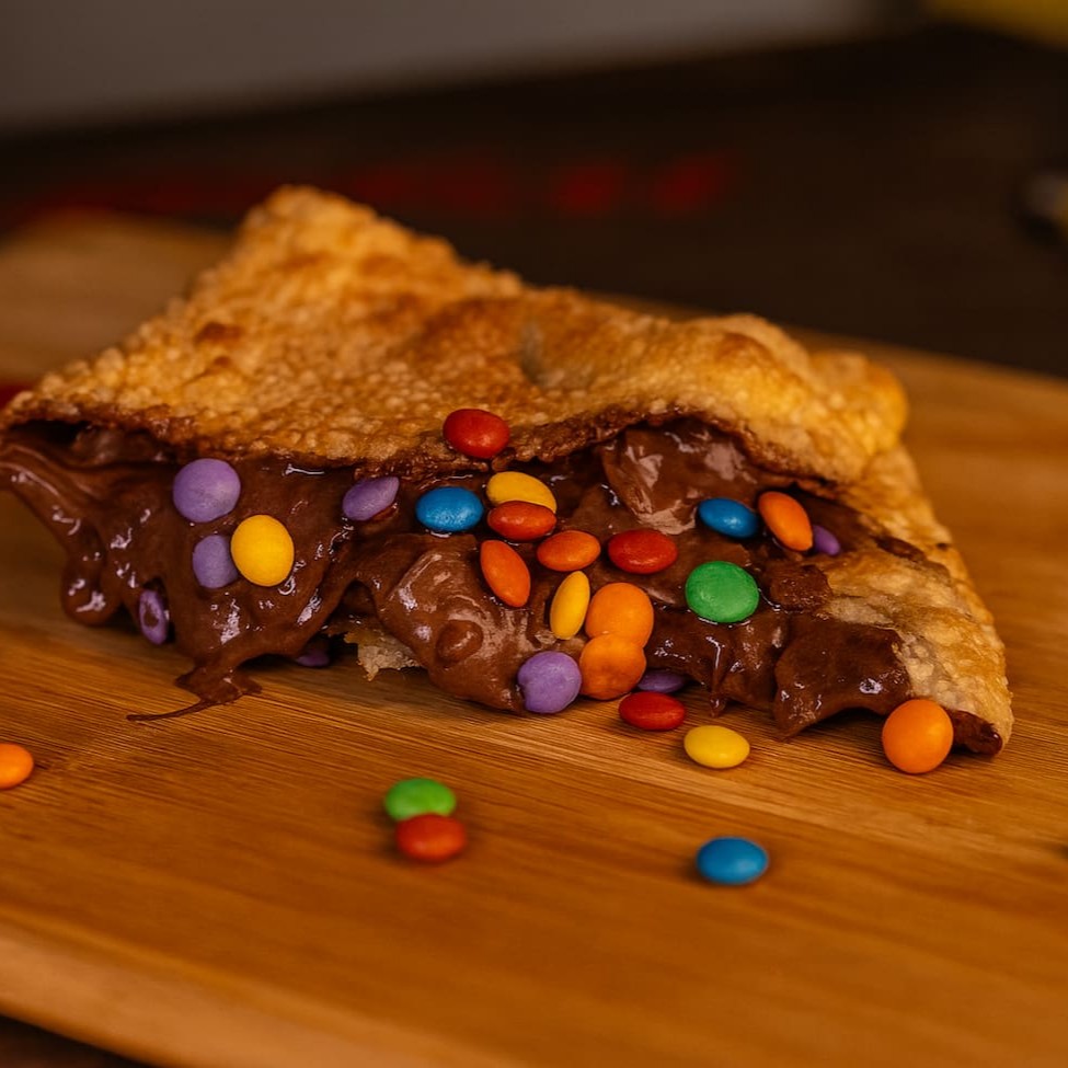 Delicioso pastel de chocolate super recheado feito com o chocolate da confeiteiro  com varios M&M no chocolate
