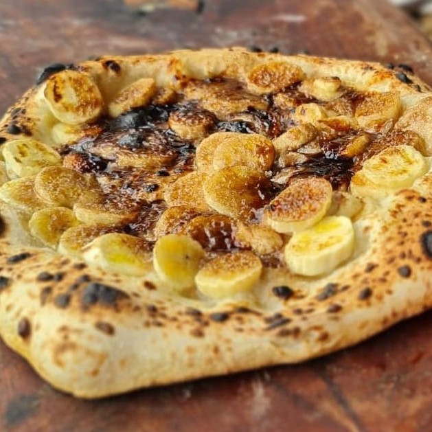 Pizza artesanal, fermentada por 100 horas, livre de industrializados e aditivos. Leva Queijo muçarela, banana, açúcar e Canela.