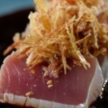 Lâminas tipo Sashimi de atum levemente maçaricado, temperado com cebolinha, gergelim e molho ponzu, finalizados com palha crocante