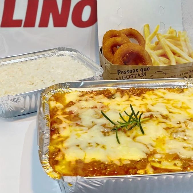 Uma deliciosa lasanha à bolonhesa acompanhada por arroz e batatas fritas. Imagem ilustrativa.