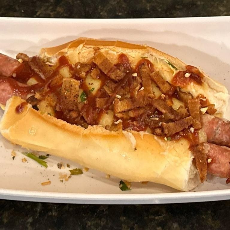 Pão com linguiça de torresmo + molho da casa + queijo mussarela + molho barbecue e lascas de torresmo.