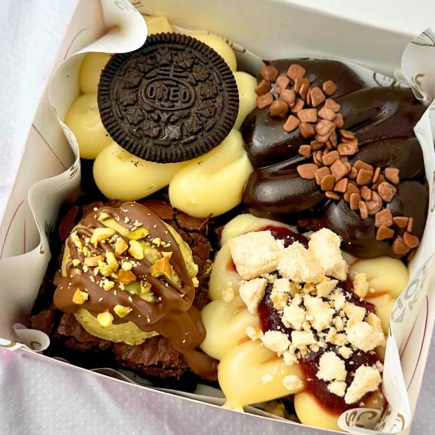 4 pedaços de brownies fudge super chocolatudo com coberturas variadas - Brigadeiro branco com geleia de morango e suspiro, Brigadeiro de chocolate com granulados de chocolate belga, Brigadeiro branco e Oreo ,Creme Dubai Pistache feito com karaifi caseiro, coberto com chocolate ao leite e pistache picado :) ~Não escrevemos Bilhetes sem a compra do mesmo que está disponível no começo e final do cardápio. A Cake Shot não altera e/ou adiciona ingredientes aos produtos já formulados. - 290g Brownie de chocolate - Dubai- brigadeiro branco - Brigadeiro de chocolate - Brownie - Merengue - Suspiro - Oreo - Frete Grátis- Promoção