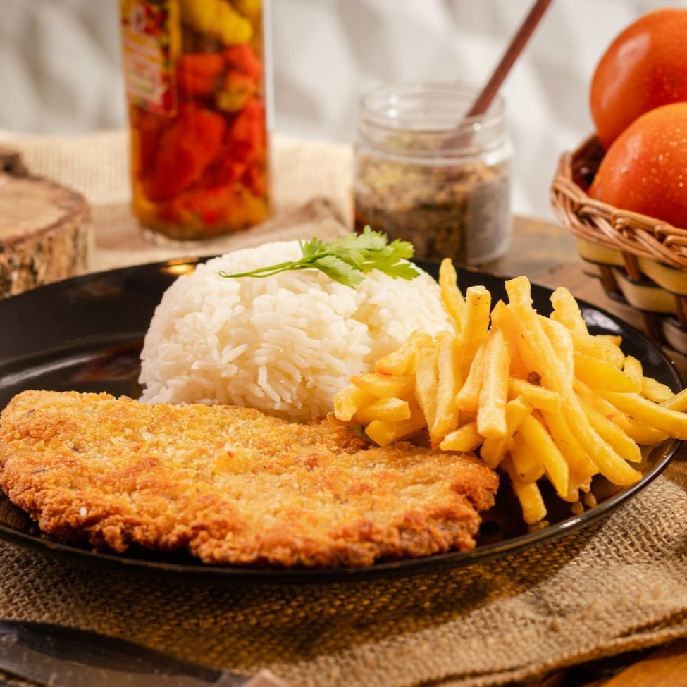 Uma deliciosa fusão de suculenta frango empanada em panko ... Servido com arroz e fritas , formando assim nosso prato a Milanesa de Filé de Frango.