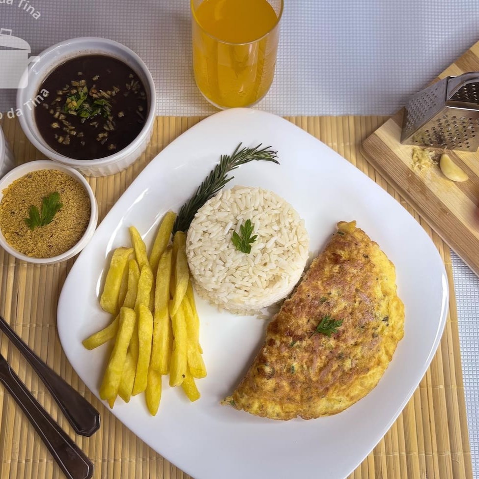 Saboroso omelete com queijo e presunto, perfeitamente temperado para realçar seu sabor único. Complementos opcionais estão disponíveis para tornar sua refeição ainda mais completa e personalizada. Uma quentinha  que traz aconchego e satisfação em cada garfada!