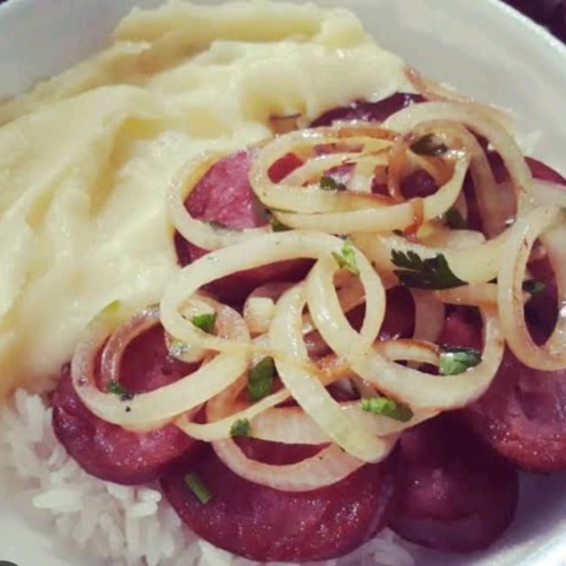 Nossa deliciosa linguiça calabresa acebolada com purê de batata vem acompanhando de arroz e feijão.