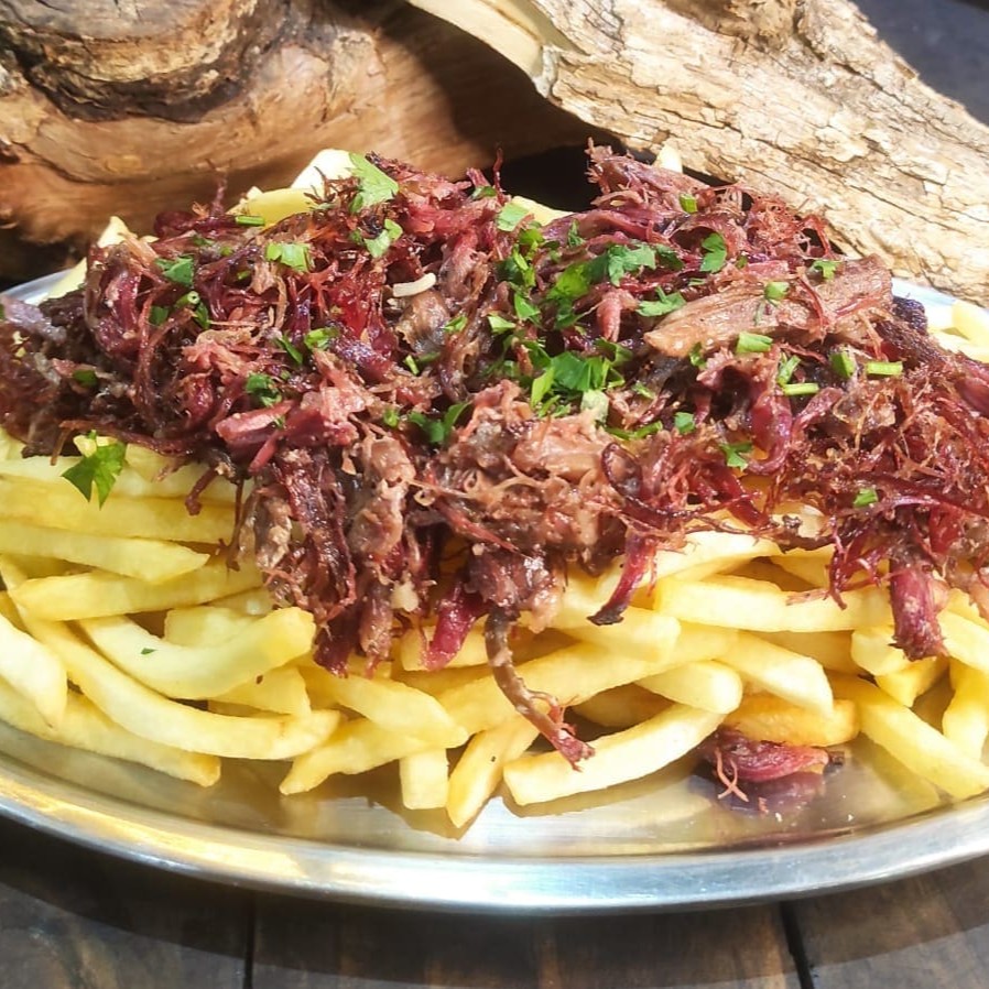Aprecie nossa incrível combinação: 500g de batata frita + costela bovina suculenta desfiada, defumada por 8 horas com nosso dry rub exclusivo. E lembre-se, todas as porções incluem um molho da casa.