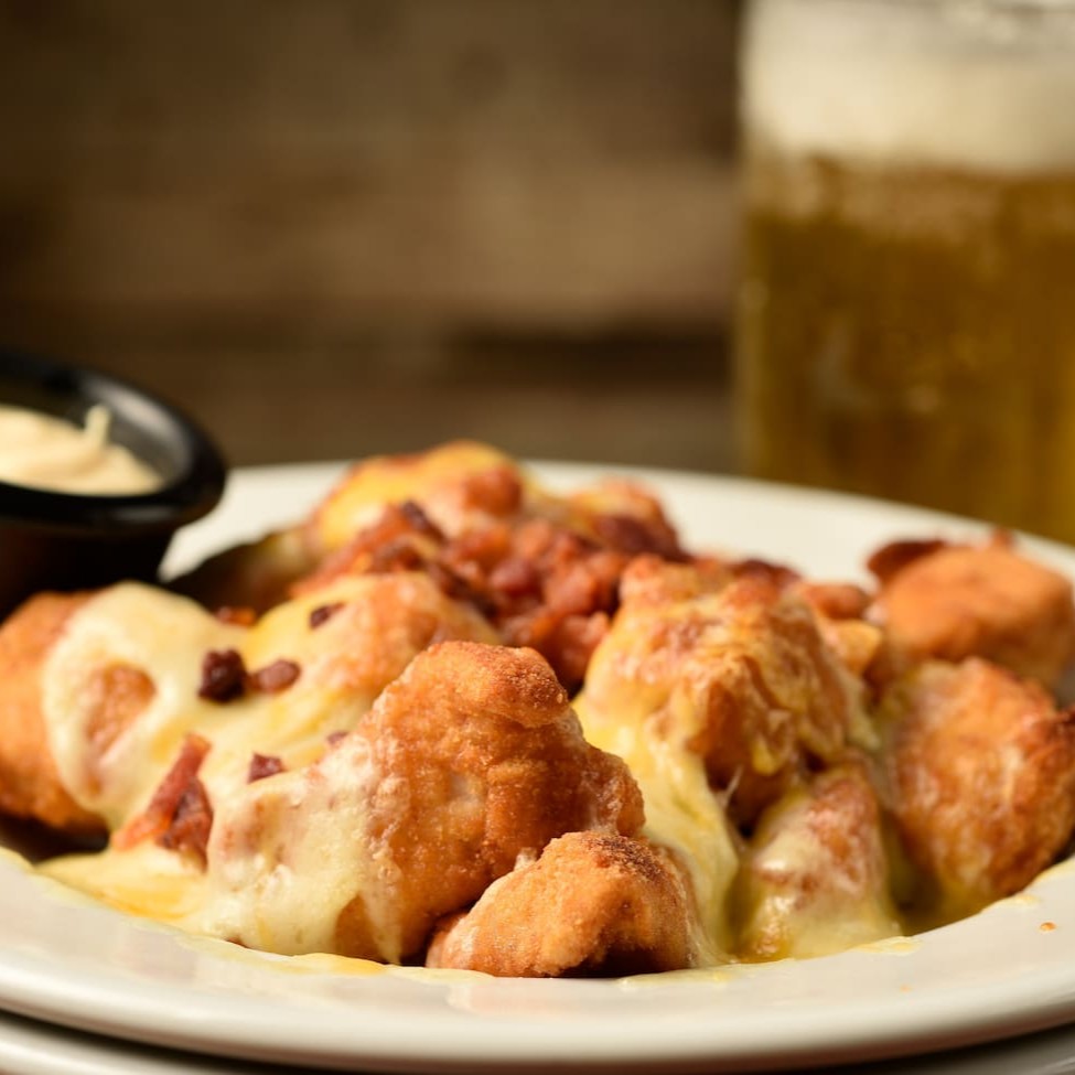 Frango em cubinhos empanados, mix de queijo, crunch bacon e molho honey mustard.