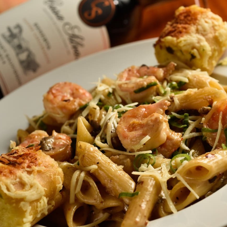 Saboroso penne com camarões junto ao molho funghi porcini. Acompanha pão de alho.