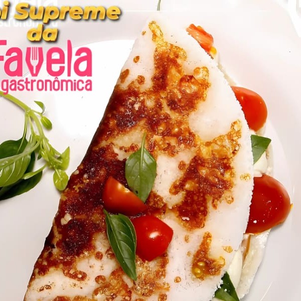 Tapi Supreme – Direto do maior evento gastronômico da nossa comunidade pra você!   Criada Exclusivamente para a 2ª edição da Favela Gastronômica da Voz da Comunidade, onde tivemos a honra de participar pela segunda vez e fazer história! ️  O sucesso foi tão absurdo que, a pedidos, a estrela do evento agora faz parte do nosso cardápio oficial!   Prepare-se pra se apaixonar: uma tapioca rendada com queijo mussarela, recheada com lombo canadense suculento, creme cheese cremoso, tomate-cereja fresquinho e um toque especial de manjericão fresco.    Peça agora a sua Tapi Supreme e sinta o sabor que conquistou a comunidade inteira! Não fique de fora dessa experiência!