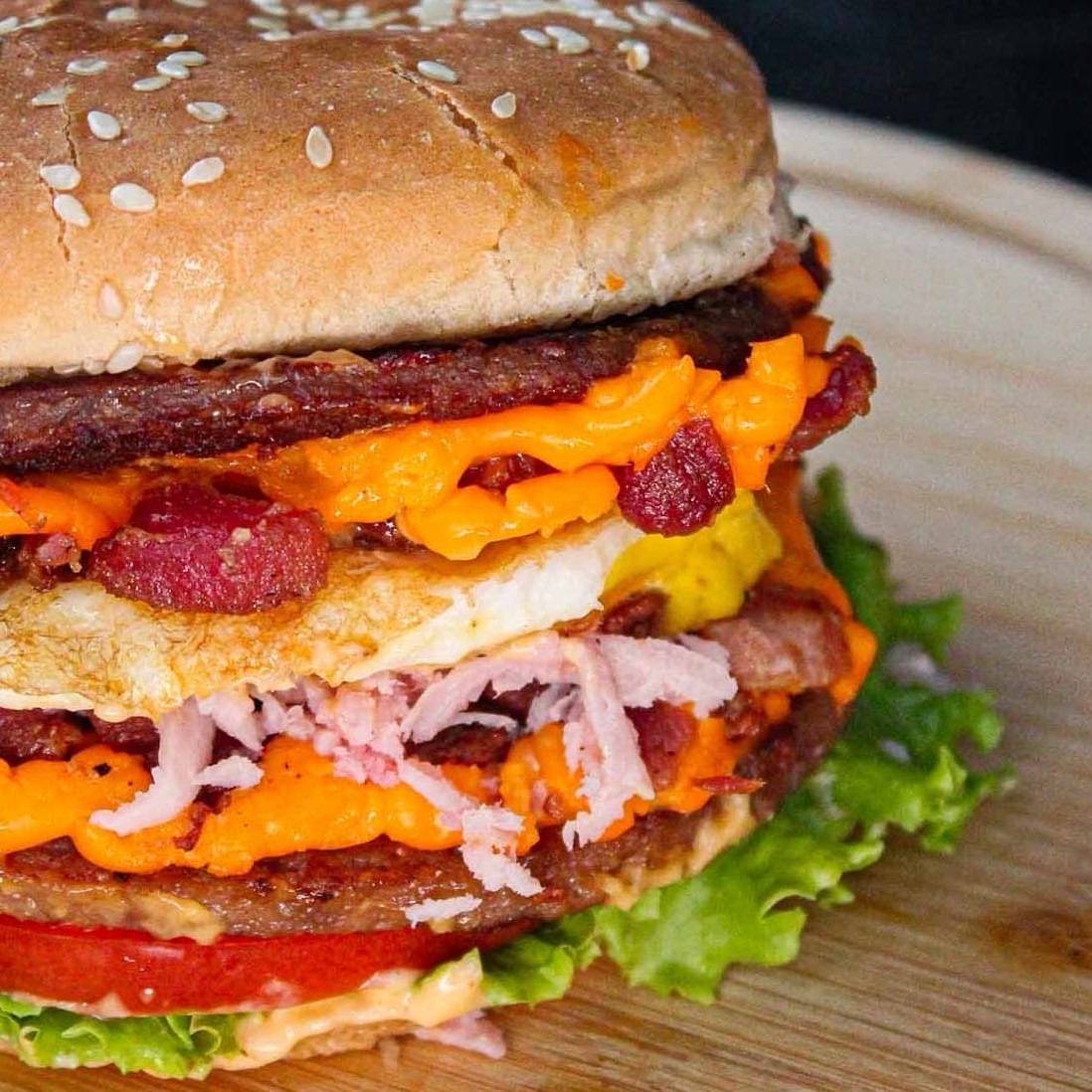 "Famosa gíria carioca ""Esse deu Aula"" Pão com gergelim, 2 carnes, cheddar, presunto, ovo, bacon, alface, tomate e molho"