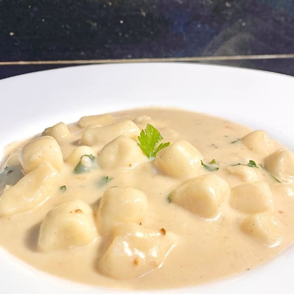 A suavidade e a cremosidade em cada garfada, perfeito para quem busca um prato delicado e envolvente.  Nhoque artesanal de batata, leve e macio, coberto por um molho branco aveludado feito com creme de leite fresco, manteiga e um toque suave de noz-moscada. Uma verdadeira experiência de conforto, que derrete na boca e aquece o coração. Embalagem especial e bem lacrada. Serve até 1 pessoa.