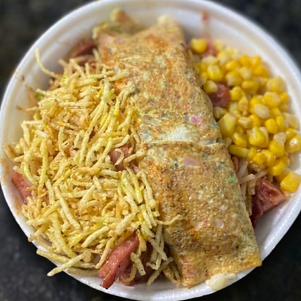 Acompanha pernil, bacon, milho, batata palha, 1 omelete recheada (Catupiry ou cheeder ), (omelete feita com presunto e orégano). Deixar na descrição preferencia para recheio. (foto ilustrativa) ( servido na marmita media 750 ml)