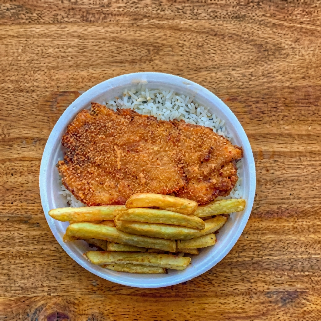 Filé de frango à milanesa, crocante por fora e suculento por dentro, acompanhado de arroz branco, feijão fresquinho, farofa temperada e batata frita douradinha. Uma refeição caseira, completa e muito saborosa, preparada diariamente pelo Quintal Urbano. 😋🍗🍟