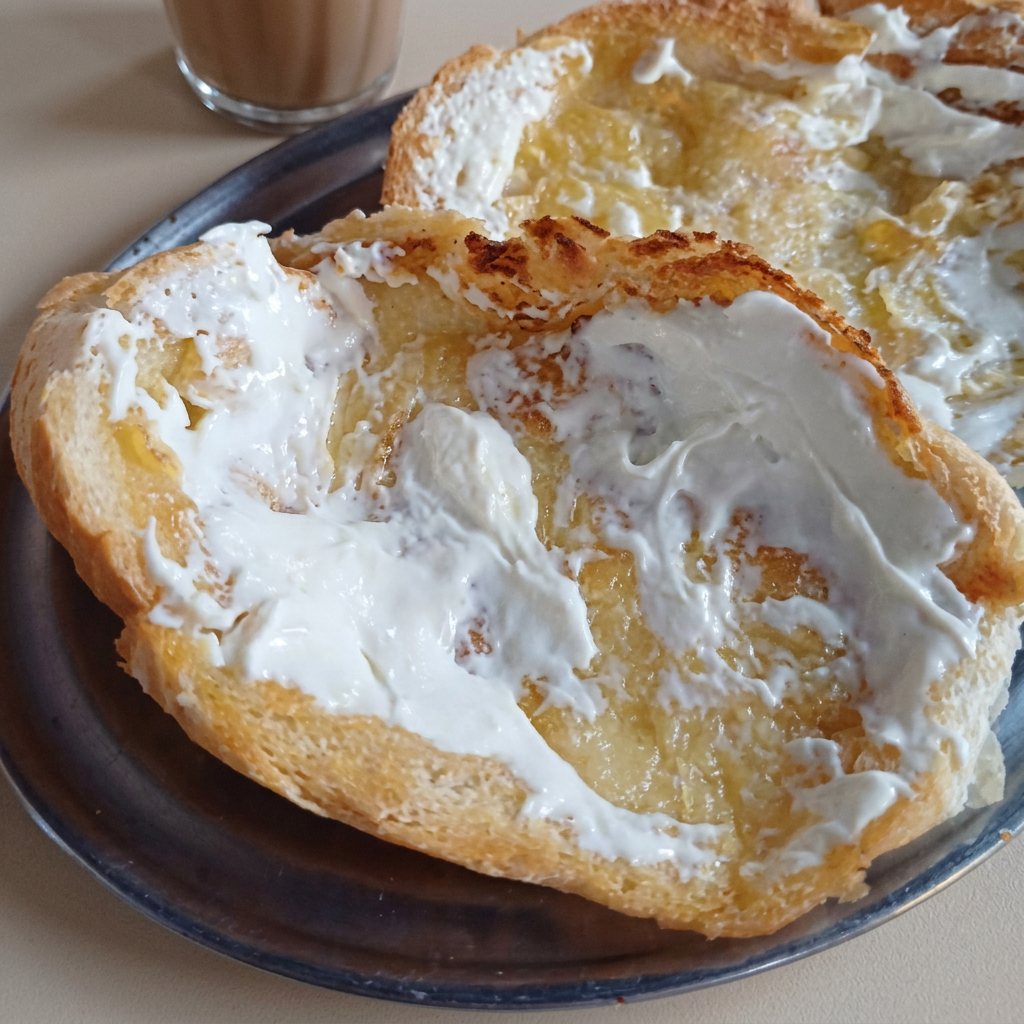 Pão tostado na chapa com manteiga e finalizado com requeijão