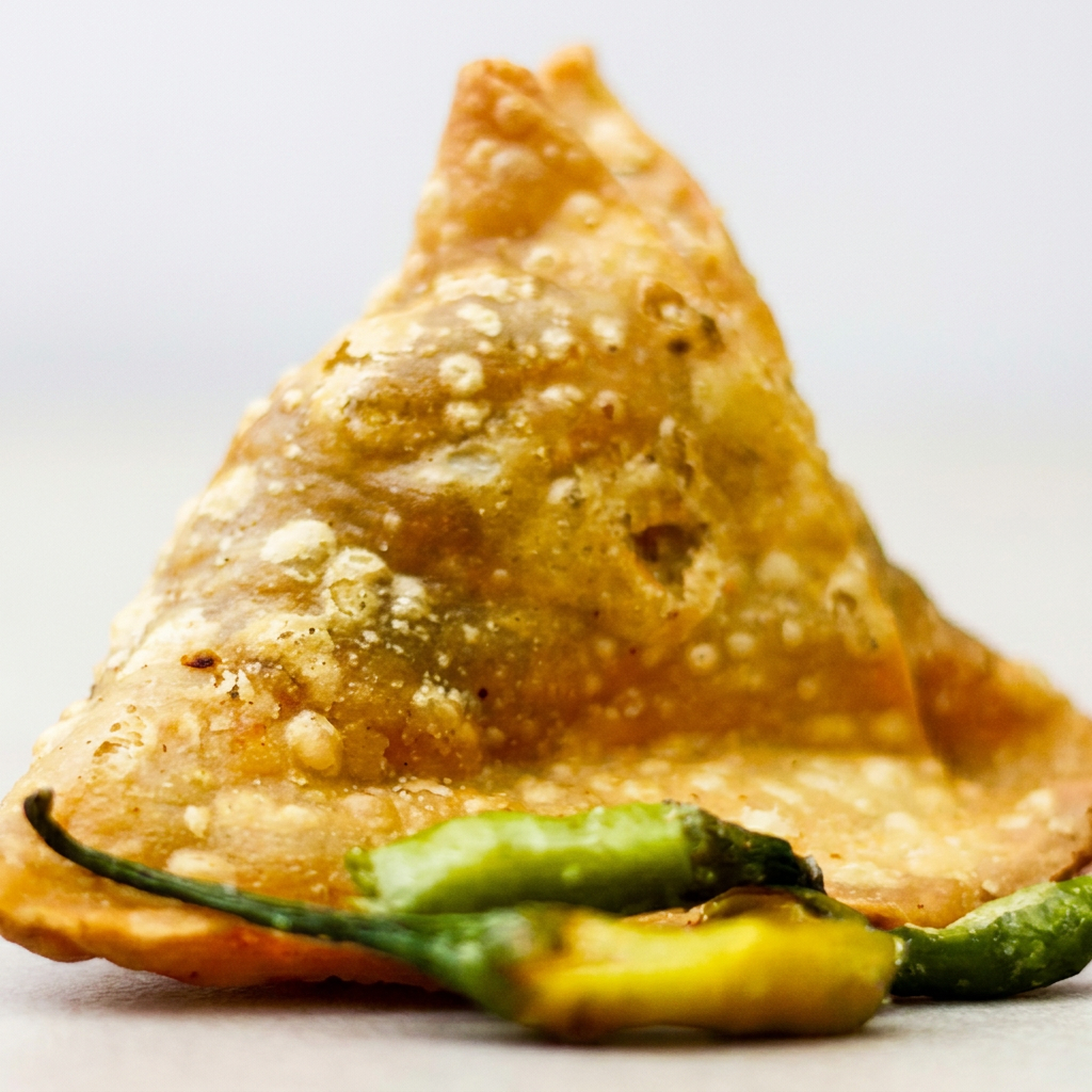 Pastel crocante frito e recheado com frango temperado com especiarias indianas.