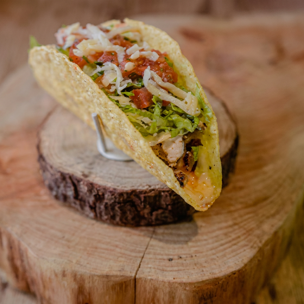 O 'Taco de Frango Don Ramon'. Esta maravilha da culinária mexicana é servida com uma tortilla de milho autêntica e irresistivelmente crocante. O recheio é composto por suculentos filetes de frango primorosamente temperados, que se unem harmoniosamente ao frescor do alface e ao sabor marcante do queijo derretido. Para finalizar, adicionamos 'Pico de Gallo', trazendo um toque mexicano.