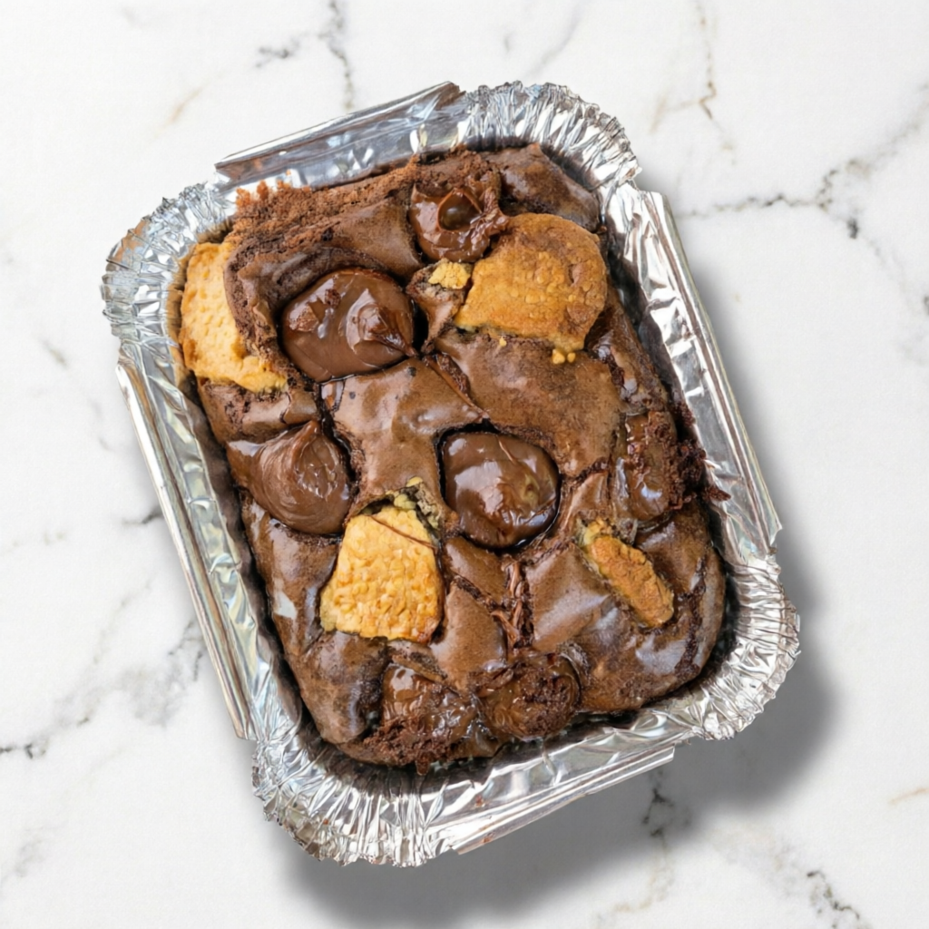 Brownie na marmitinha com pedaços de Chocolate branco e Nutella. Pode ser aquecido no microondas sem a tampa. Aprox. 110g