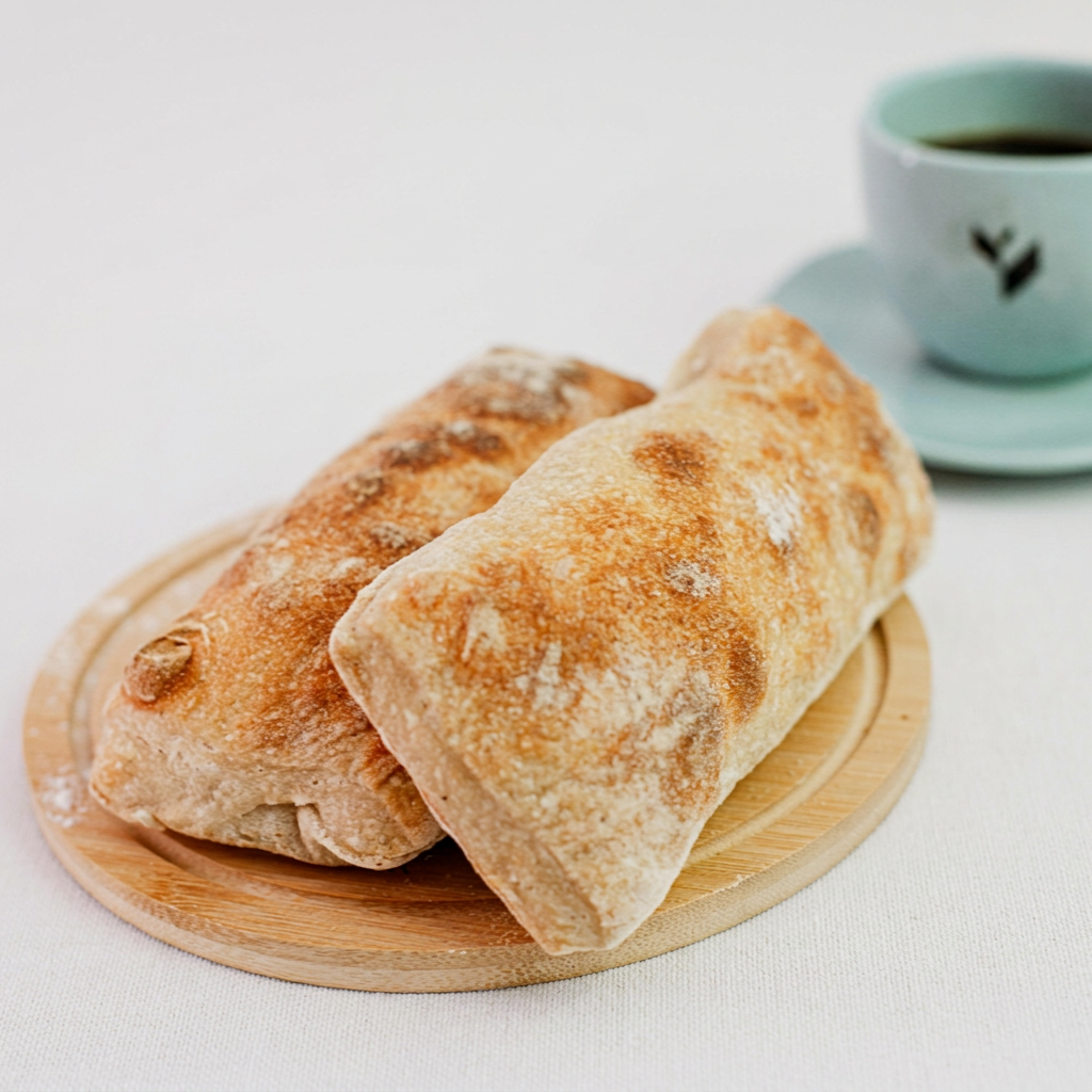 Pão ciabatta artesanal, com uma crosta dourada e interior areado, perfeito para bruschettas.