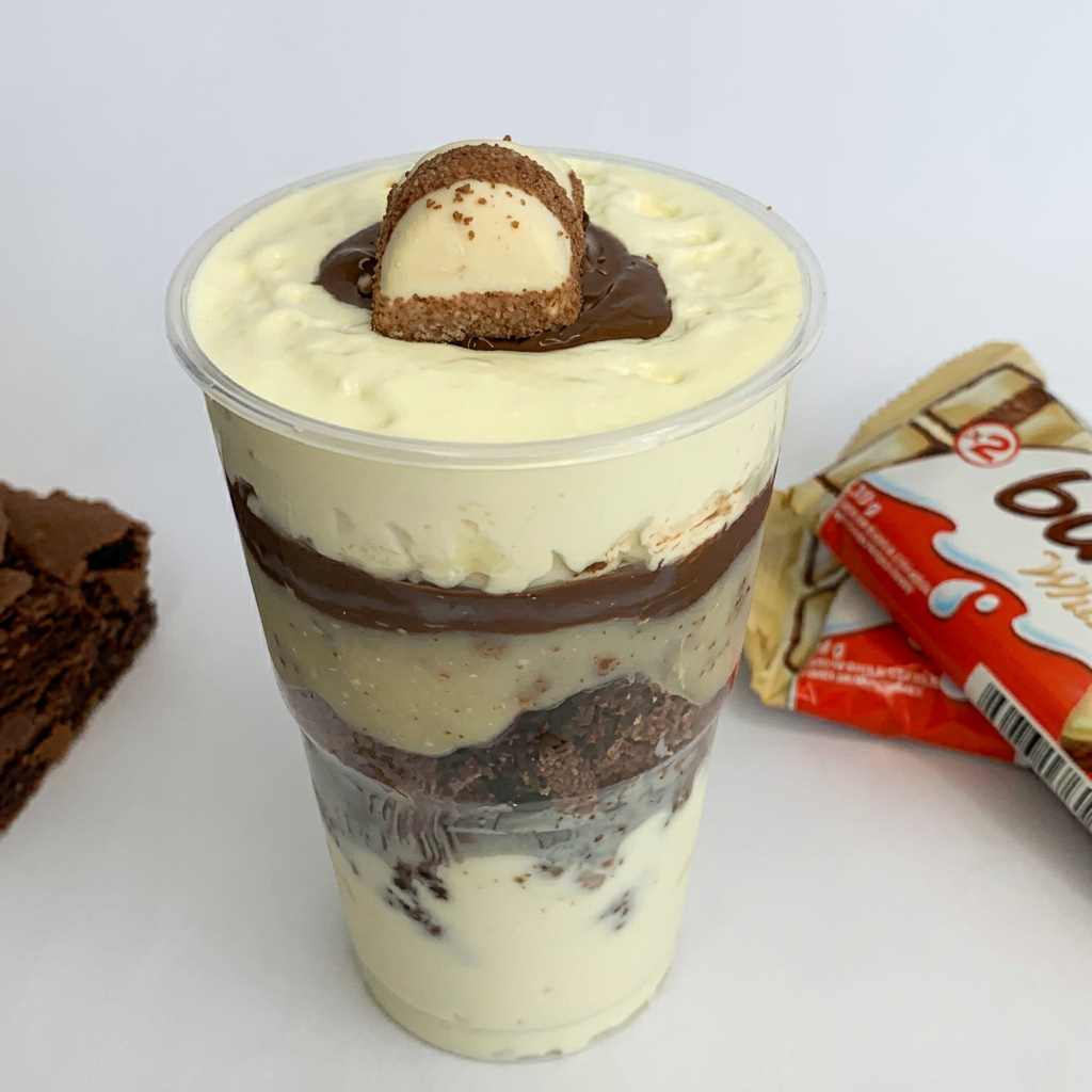Mousse de leite Ninho, Brownie em pedaços com brigadeiro de leite Ninho, pedaços de Kinder Bueno, uma camada de Nutella. Finalizado com Kinder Bueno