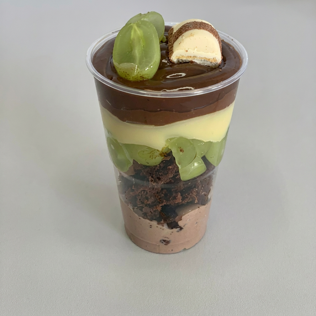Feito com mousse de chocolate com pedaços de Brownie, uva verde fresca, brigadeiro cremoso de leite ninho, Nutella pura e brigadeiro de cacau 50% .
Finalizado com brigadeiro de chocolate uva verde e Kinder Bueno.