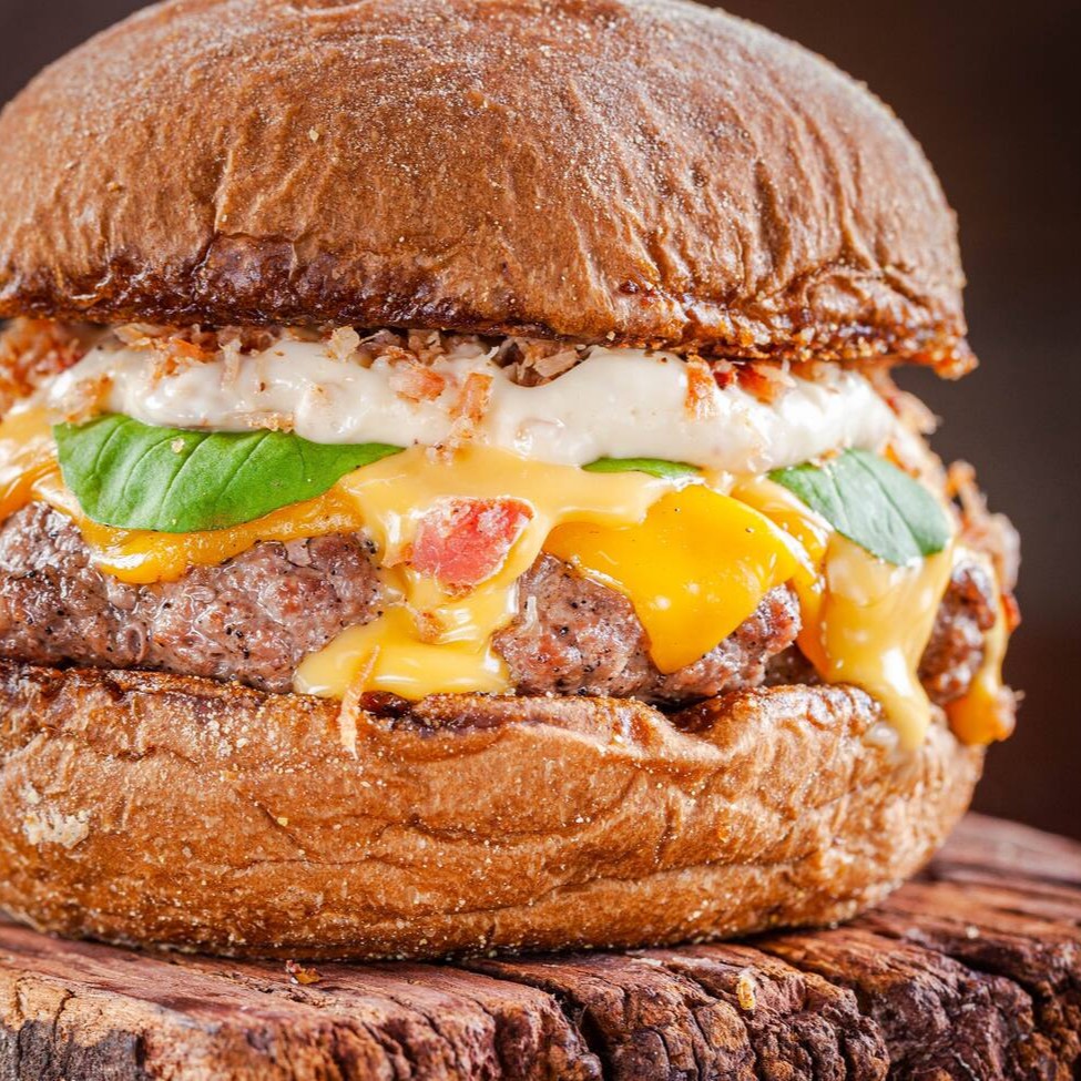 Blend 150g, Queijo Cheddar, Maionese de bacon, , creme de cheddar artesanal, farofa de bacon e rúcula fresca no pão australiano.