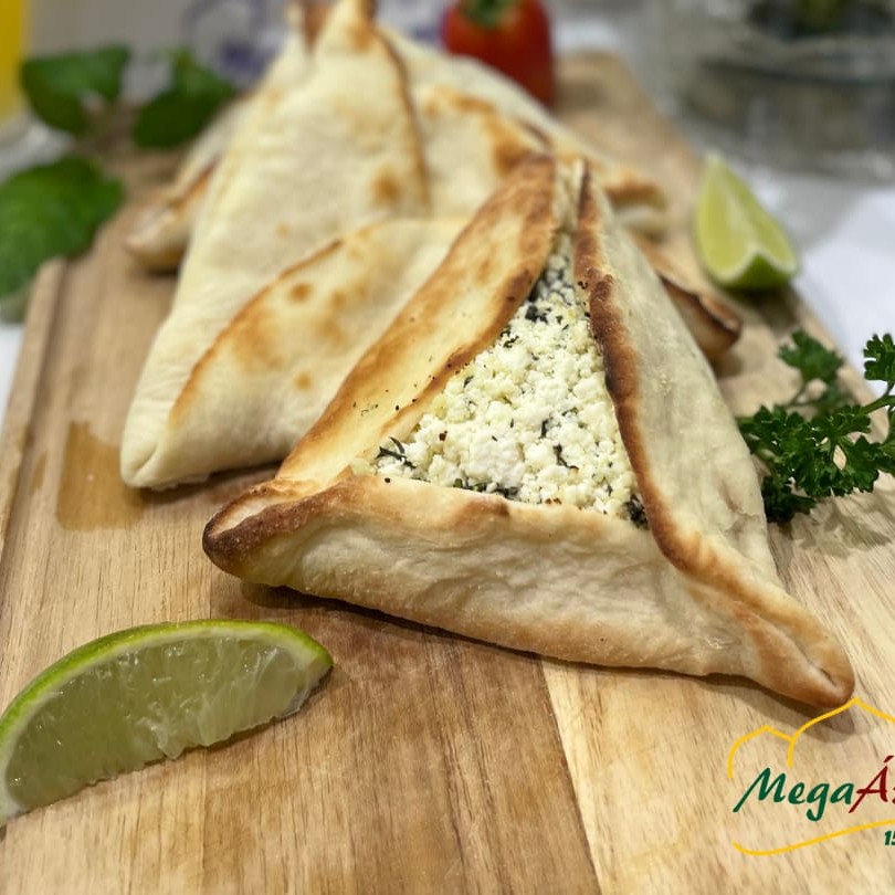 Esfiha de Ricota: Artesanalmente Deliciosa!  Desfrute da perfeição artesanal em cada mordida com nossa Esfiha de Ricota. Cada uma delas é meticulosamente preparada com farinha de trigo importada, conhecida por sua qualidade excepcional.  Ricota Fresca e Hortelã: O recheio desta esfiha é um verdadeiro tesouro de sabor. Ela é recheada com ricota fresca e hortelã, que são cuidadosamente temperados à