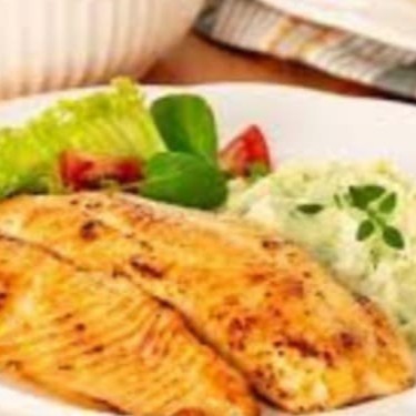 Delicioso filé de tilápia acompanhado de arroz, purê e salada verde.
