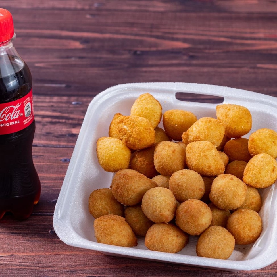 25 unidades das irresistíveis Coxinhas de frango + Coca-Cola Geladinha 200ml Grátis 10g aprox. Cada coxinha - tamanho festa.