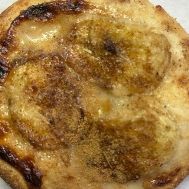 Uma massa deliciosa e caseira de esfirra forneada, com rodelas de banana, gotas  de essência de baunilha, canela em pó, finalizada com leite condensado e açucar cristal.